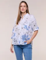 Camisa de lino sintético con estampado floral en tonos azules y beige sobre fondo blanco, de corte holgado, mangas tres cuartos y cuello camisero.