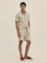 Short de lino y algodón a rayas beige con un toque plateado, con cintura elástica y cordón de algodón, y bolsillos laterales.