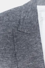 Blazer azul confeccionado en lino, con cuello solapa, manga 3/4 remangada con trabilla y botón, y bolsillos con solapa en delantero.