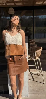 Top de diseño combinado con tejido de crochet en la parte superior y cuero en la inferior, con escote en V y tirantes finos.