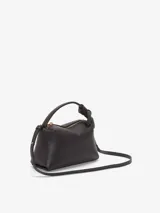 Bolso de mano color negro, con asa corta y cierre superior con cremallera.