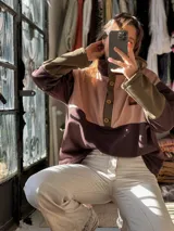 Buzo oversize de friza de algodón y poliéster, con diseño colorblock en tonos verde militar, marrón y rosado. Cuenta con cuello alto, solapa con botones frontales y mangas largas.