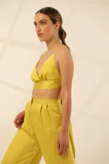 Top de satén color amarillo, con escote en V, espalda descubierta y breteles ajustables.