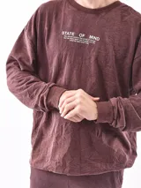 Buzo de cuello redondo y manga larga, con diseño holgado y estampado frontal con texto.