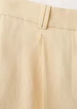 Pantalón de traje de tiro medio color amarillo claro, con diseño recto, bolsillos laterales y trabillas para cinturón. Confeccionado en mezcla de lino, viscosa y lyocell.