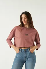 Remera de manga larga y corte boxy color marrón rosado, con cuello redondo y estampa frontal con la leyenda "HER TRUE".