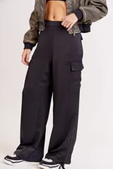 Pantalón de vestir color verde oliva, de corte ancho y tiro alto, con bolsillos laterales tipo cargo y detalle de pinzas en la cintura.