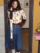 Sweater de punto jersey tejido a mano en 100% lana merino, de diseño multicolor con motivos de ciervos, árboles y flores bordados. Presenta cuello alto y puños en color marrón oscuro.