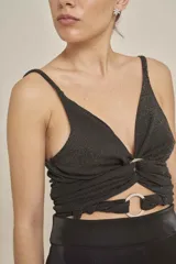 Top negro con destellos brillantes, tirantes finos, escote en V pronunciado, detalle drapeado con argollas metálicas en el centro y diseño cut-out.