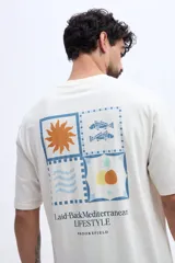 Remera oversize de manga corta color celeste, de corte relajado y amplio, confeccionada en algodón. Presenta un gran estampado en la espalda dividido en cuatro paneles con motivos gráficos (un sol, peces, ondas y formas abstractas) junto con inscripciones de la marca y estilo de vida.