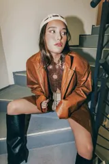 Top marrón de cuero con cuello halter y espalda descubierta. Diseño con detalle de círculo calado en el centro y ajuste con lazos.