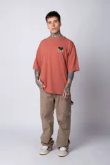 Remera negra de algodón de corte oversize, con mangas cortas y cuello redondo. Estampado pequeño en el frente y diseño grande en la espalda con Mickey Mouse y caracteres orientales en tonos rojizos.