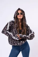 Campera con capucha de estilo deportivo, confeccionada en tejido aterciopelado con estampado animal print de leopardo. Presenta cierre frontal, mangas largas con doble franja lateral blanca y puños elásticos.