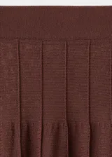 Falda larga de punto fino en color marrón chocolate, con diseño evasé y cintura elástica. Presenta un acabado con costuras verticales decorativas a lo largo de la prenda.