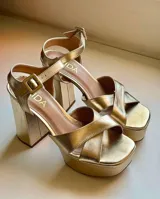 Sandalias plateadas de fiesta con tiras cruzadas en el empeine, plataforma delantera y tacón cuadrado alto.