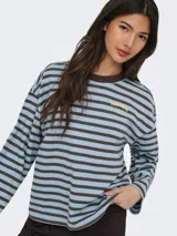 Remera de manga larga a rayas horizontales en tonos marrón y tostado, con cuello redondo y el texto "vibrant studio" estampado en el pecho.