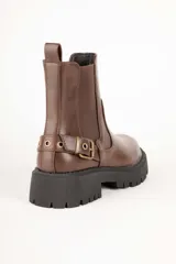 Botas de caña baja color negro, símil cuero, con pieza elastizada en sus laterales, aplique de hebilla metálica y plataforma de 5cm de alto.