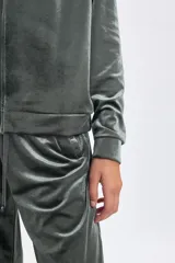Campera deportiva con cierre frontal, confeccionada en tela de plush con acabado brillante. Presenta mangas largas tipo raglán, capucha con cordones ajustables y puños elásticos.