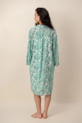 Vestido midi verde con estampado de arabescos, cuello camisero con escote en V y cierre frontal parcial de botones, de manga corta y corte recto.