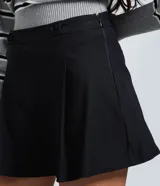 Short de bengalina color negro con cintura estructurada, detalle de botones decorativos y cierre frontal. Presenta un corte evasé que aporta volumen y estructura a la silueta.