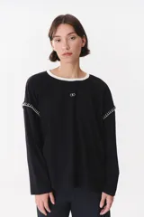 Remera de manga larga con corte oversized, color azul marino con cuello redondo en contraste color marrón. Presenta costuras decorativas a contratono hechas a mano en la zona de los hombros y logo bordado en el centro del pecho.