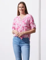 Blusa de gasa estampada en tonos rosados y blancos, marca Ruby Rd. Tiene cuello a la base, escote en v y abertura con botones. Delantera con bolsillos. Largo de manga regulable con presilla y botón. Terminación de ruedo con nudo.