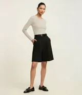 Blusa de manga larga con cuello redondo, confeccionada en algodón con un toque de elastano. Presenta un diseño básico, liso y ajustado al cuerpo.