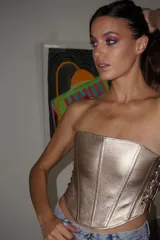 Top corset dorado de cuero ovino, con ajuste de cordones en los laterales.