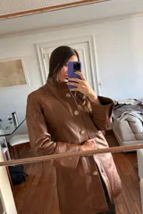 Tapado largo de cuero ovino color caramelo con cuello de piel sintética desmontable, detalles de pasamanería a tono en hombros y espalda y botones de guampa.