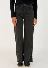 Pantalon de corte recto y tiro medio, confeccionado en gabardina color marrón. Presenta cierre frontal con botón y bolsillos laterales.