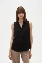 Musculosa de poliéster color blanco, con cuello en V y diseño holgado sin mangas.