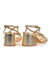 Sandalias doradas con tiras trenzadas y taco geométrico.