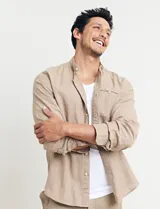 Camisa de cuello mao y manga larga, confeccionada en una mezcla de lino y algodón. Presenta un diseño de corte recto con botones en tono natural y un bolsillo pequeño en el pecho.