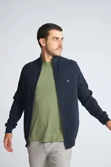 Campera tejida de algodón con cierre frontal completo, cuello alto y mangas largas. Presenta un diseño básico con logo bordado en el pecho.