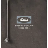Canguro con capucha y cordón ajustable de color gris oscuro, con bolsillo tipo canguro y un pequeño estampado gráfico rectangular en el pecho con el texto "Katin".