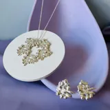 Collar plateado con dije circular con diseño abstracto y cadena fina.