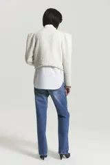 Saco corto rojo con textura tweed y cuello con solapa con flecos blancos.