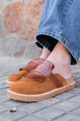 Mules de cuero color marrón con detalle de flecos en la capellada y suela de goma.