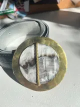 Cinturón dorado con hebilla texturada y piedra ágata en tonos violeta.