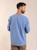 Remera de manga larga gris oscuro con cuello redondo y bolsillo en el pecho.