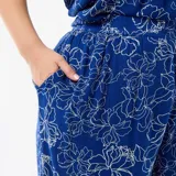 Pantalón ancho de punto crepé color azul con estampado floral en tono claro, de tiro alto y corte holgado.