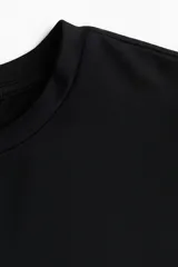 Remera entallada de microfibra en color negro, con cuello redondo fino y mangas cortas.