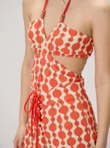Top halter estampado en tonos rojo y beige, con tirantes finos ajustables al cuello y detalle de cuentas.