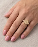 Anillo de plata y oro con diseño de San Benito, presenta una medalla circular grabada en el frente y detalles de alambre en los laterales del aro.