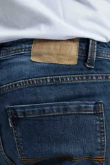 Jean de hombre color azul con efecto gastado y roturas.