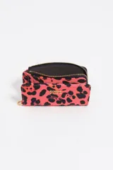 Billetera de tamaño mediano confeccionada en nylon, con cierre de cremallera y tirador de cordón. Presenta estampado animal print en tonos fucsia y negro, con logo metálico dorado en el frente.