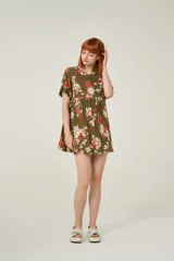 Vestido corto de viscosa con estampado floral en tonos verdes, rojos y blancos. Presenta un diseño holgado con cuello a la base y mangas cortas con volados en los extremos.