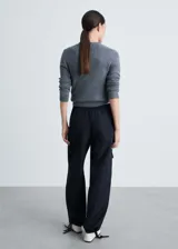 Pantalon de corte recto y tiro medio, confeccionado en tejido técnico de poliéster. Presenta cintura elástica, bolsillos laterales y bolsillos de parche con solapa en las piernas. El bajo cuenta con un sistema de fruncido regulable.