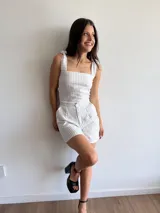 Top a rayas verticales blancas y grises, con breteles anchos que se atan en los hombros y espalda con cordones cruzados.