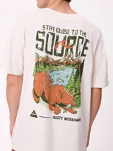 Remera de corte oversize color crema con estampado gráfico en la espalda que muestra un oso, un paisaje natural y el texto 'Stay close to the source'.
